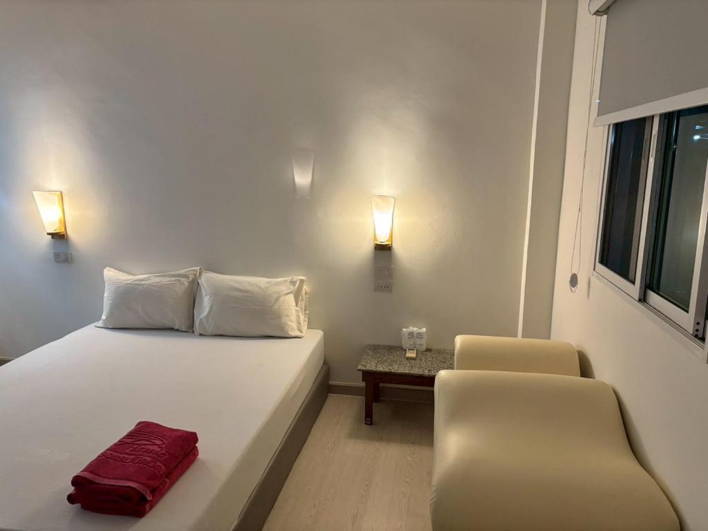 a bedroom with a bed and a chair and lights at Picnic Si Racha in Ban Fang Daeng