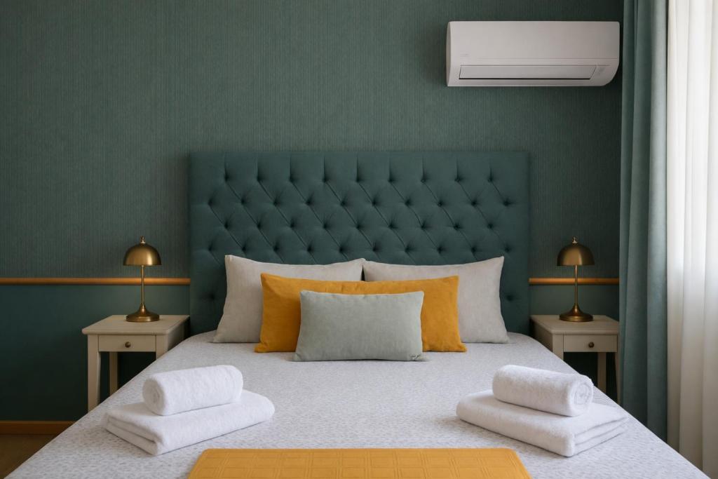 a bedroom with a large bed with a green headboard at Allegoria House in Nafplio