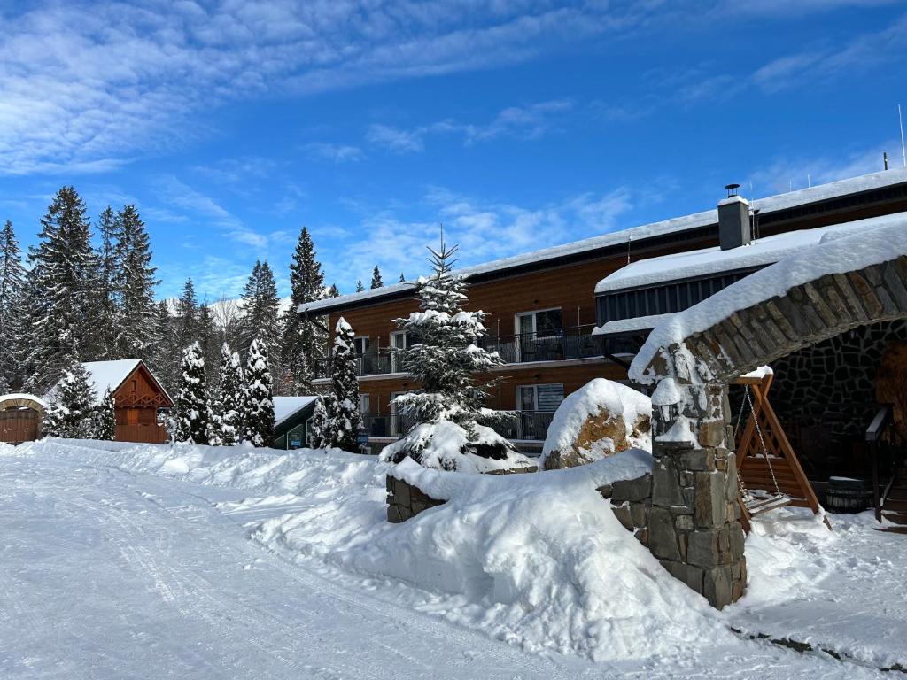 a snow covered yard in front of a lodge at Apartman Tatranská Štrba in Štrba