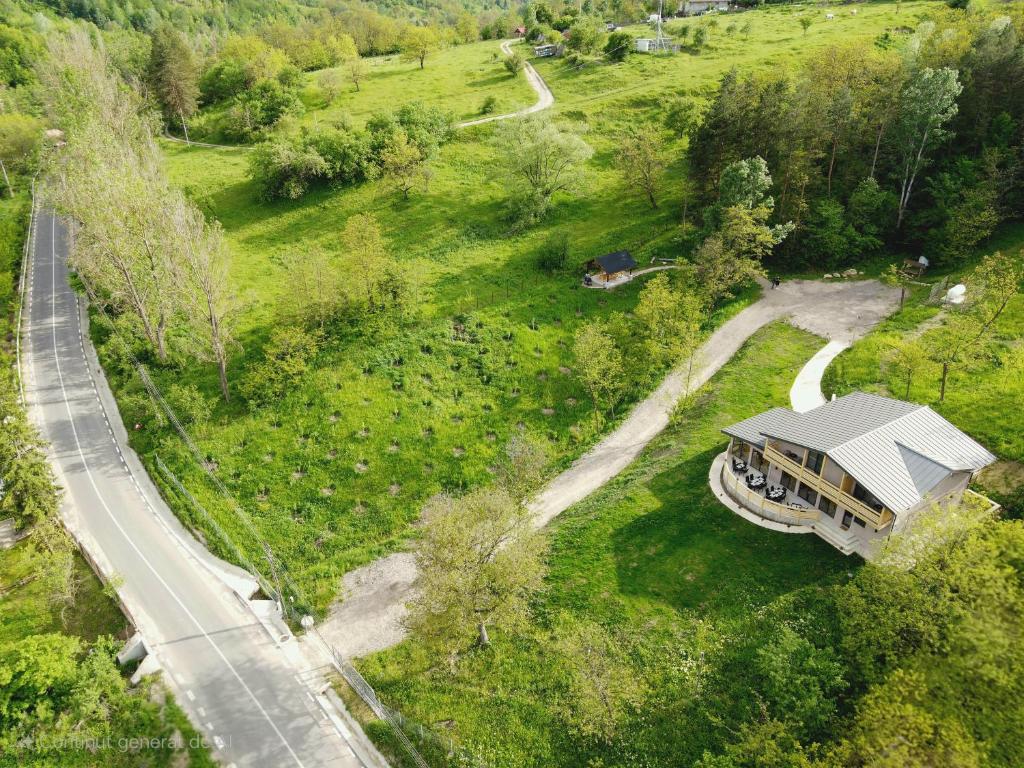 an aerial view of a house in a field with a road at ZAMURA Casa in Bozioru