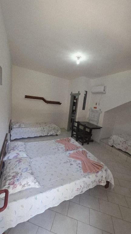 a bedroom with two beds and a desk in it at Verde & Sal 09 in Ilhéus