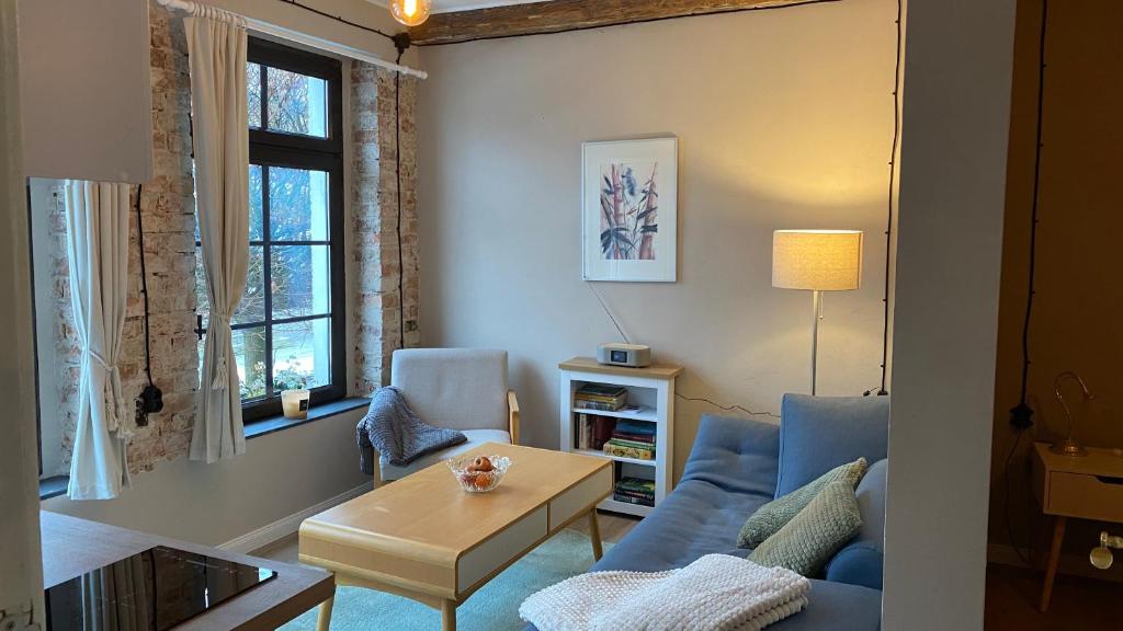 a living room with a blue couch and a table at Kleine Auszeit in Oderberg