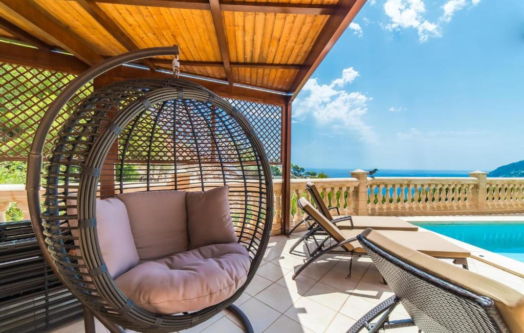 a porch with a rattan chair and a pool at Torre De Heretat in Canyamel