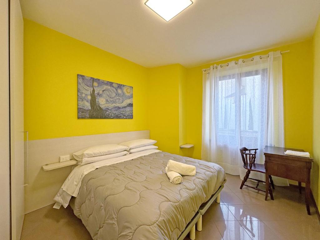 a yellow bedroom with a bed and a desk at BBkey Corte San Daniele in San Daniele del Friuli