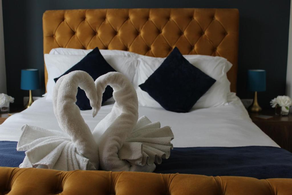 two towel swans sitting on top of a bed at Oliver Wests Beautiful 1 Bedroom Retreat in Scarborough