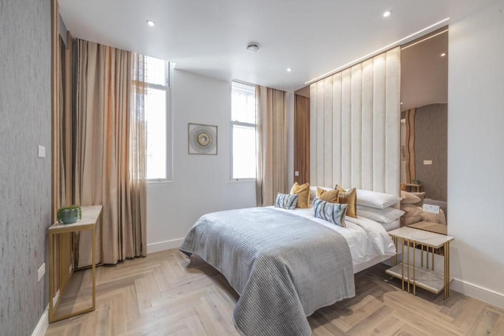a bedroom with a large bed with blue pillows at The Pocklington Aparthotel - Luxury 1 & 2 Bed Serviced Apartments, City Centre, Perfect For Families, Contractors and Businesses in Leicester