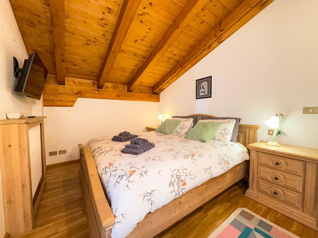 a bedroom with a bed and a wooden ceiling at Casa Flora -lakefront and Tre Cime view in Auronzo di Cadore