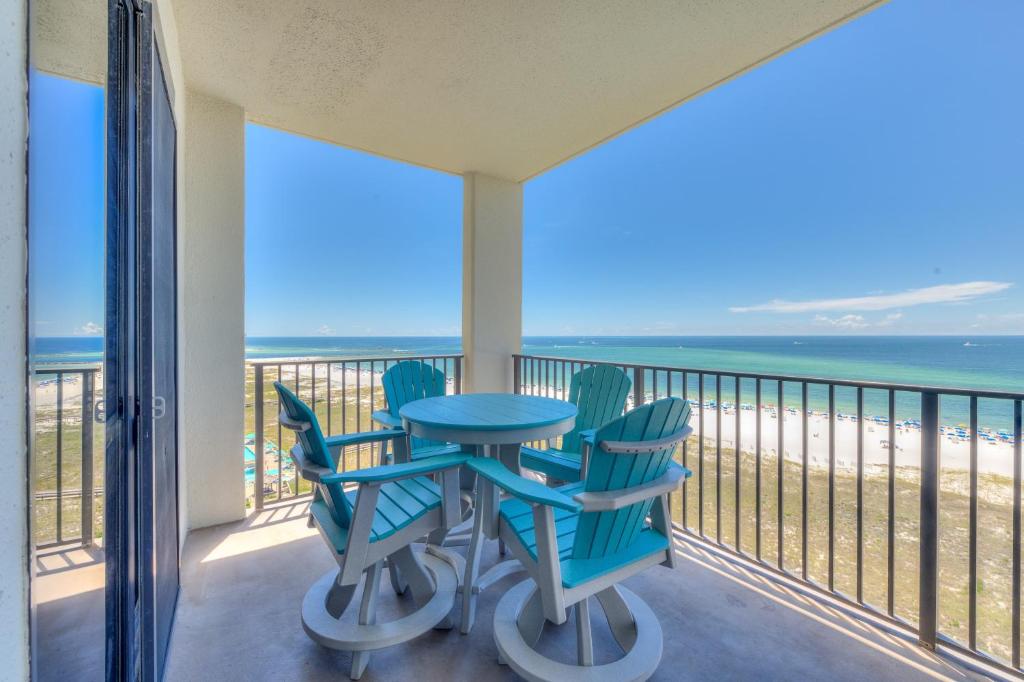 a balcony with a table and chairs on the beach at Phoenix 6 Unit 1209 in Orange Beach