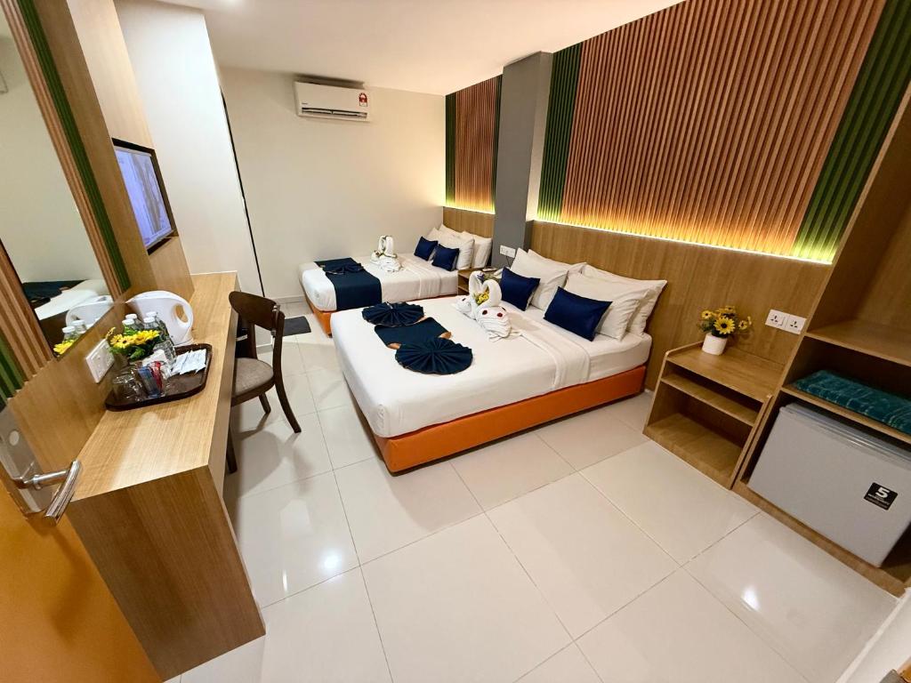A two-bed room with a desk, beverage station, television, air conditioner and storage bench.