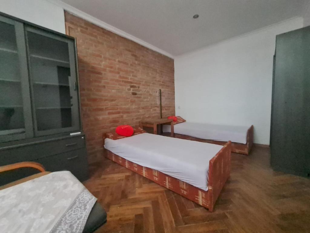 a room with two beds and a brick wall at Noclegi w Sercu Miasta in Sanok