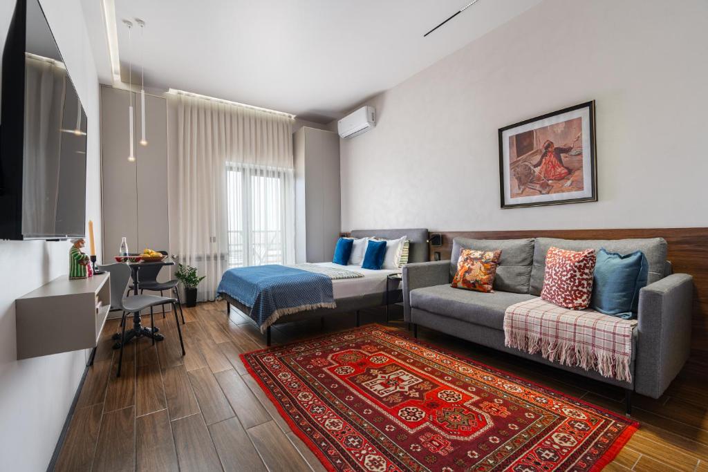 a living room with a couch and a table at Blueloft 47 l studio with balcony Tashkent City Center in Tashkent