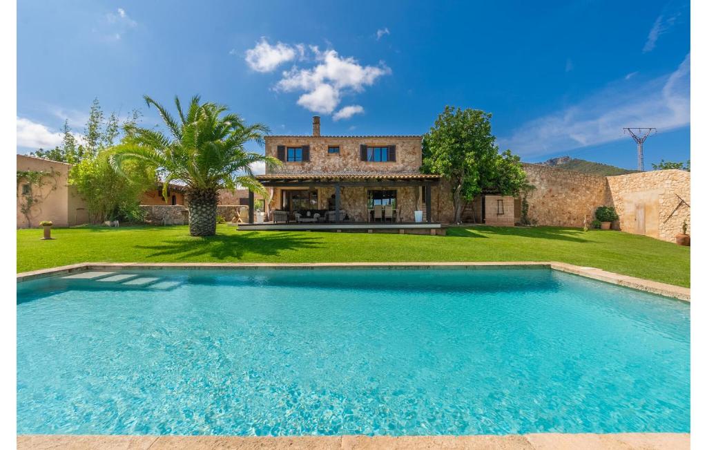a large swimming pool in front of a house at Es Sequer in Felanitx