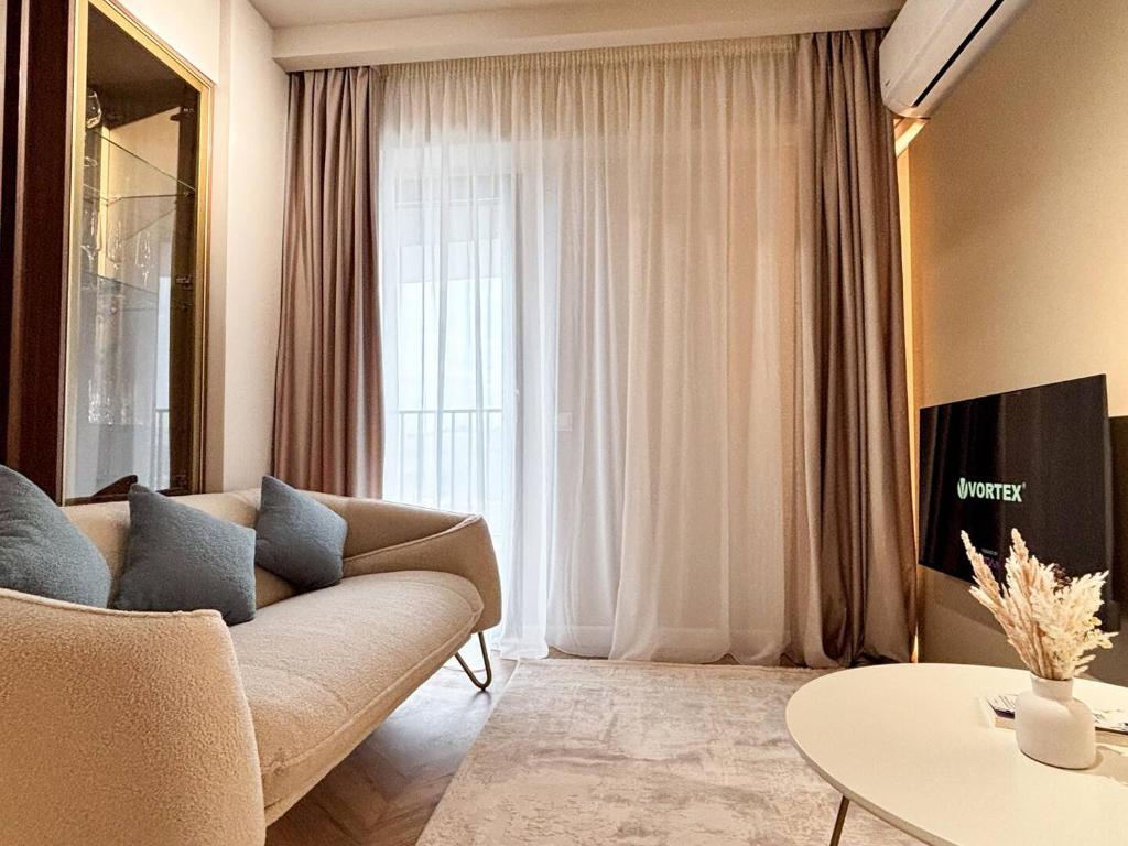 a living room with a couch and a table at YANG 23rd Floor Panoramic View & King Bed, Parkin in Cluj-Napoca