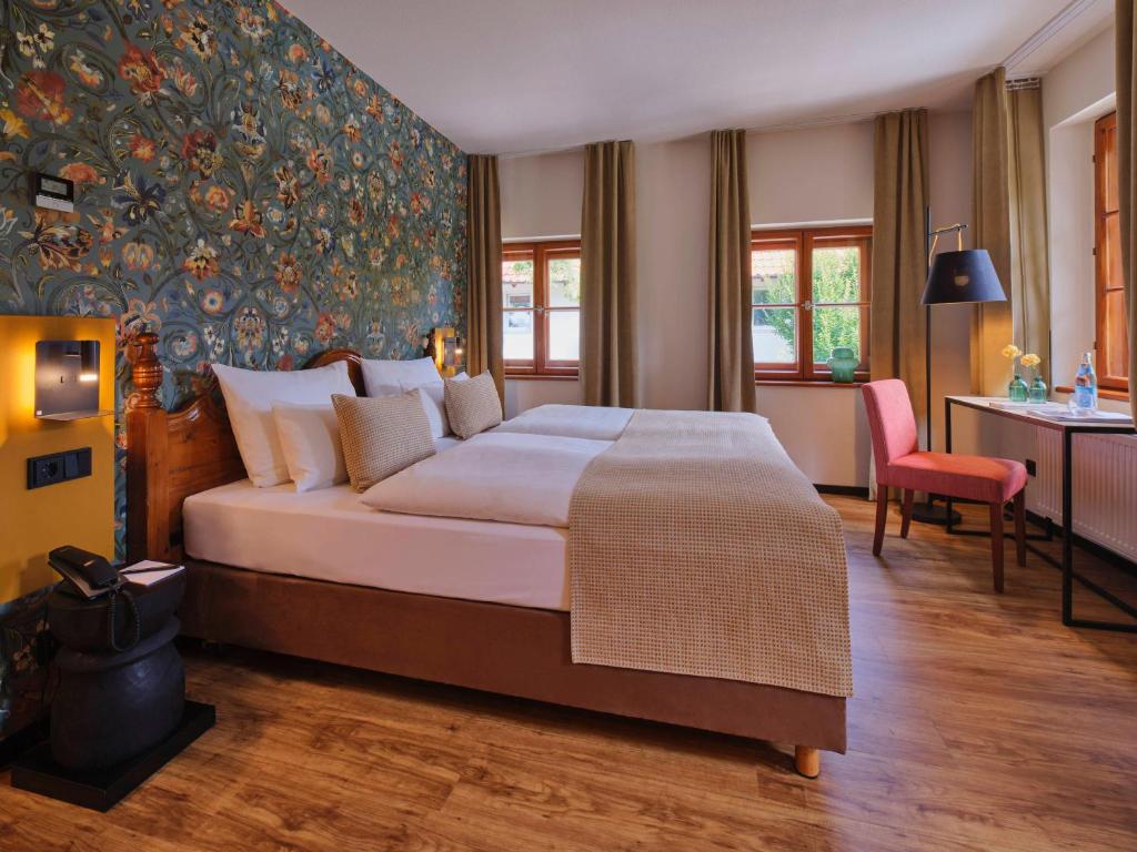 a hotel room with a large bed and a desk at Classik Hotel Martinshof, Messe München in Munich