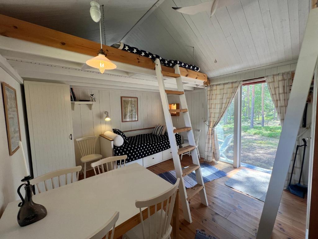 a bedroom with a bunk bed and a dining room at Cozy Studio on Utö Near Beach & Restaurant in Utö