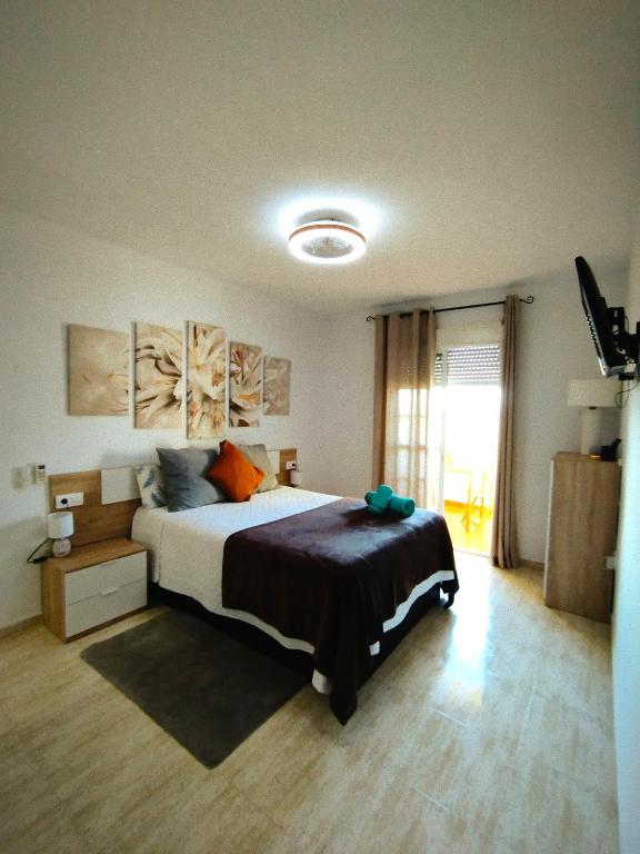 a bedroom with a large bed and a window at Las Salinas in Roquetas de Mar