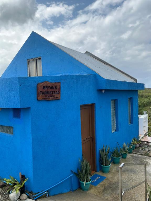 a blue building with a sign on it at Bryans Farmstead in Basco