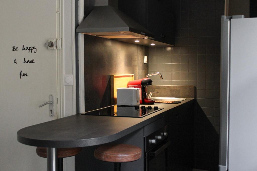 a kitchen with a black counter top and a sink at Le Duplex appartement proche de la Cathédrale in Bayeux