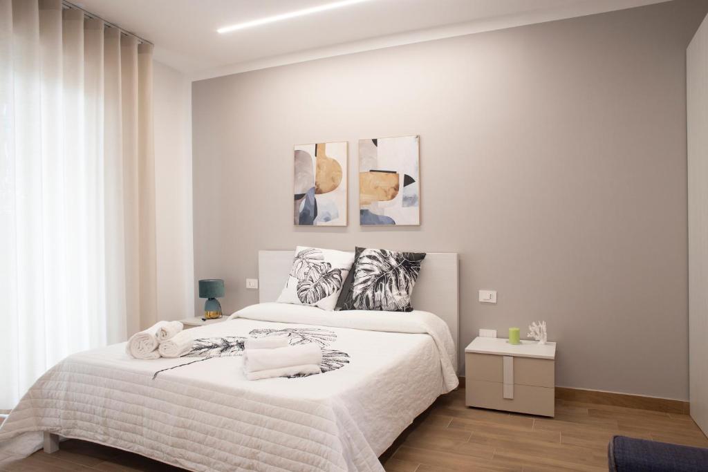 a white bedroom with a large bed with white sheets at Acquamarina B&B in Vasto