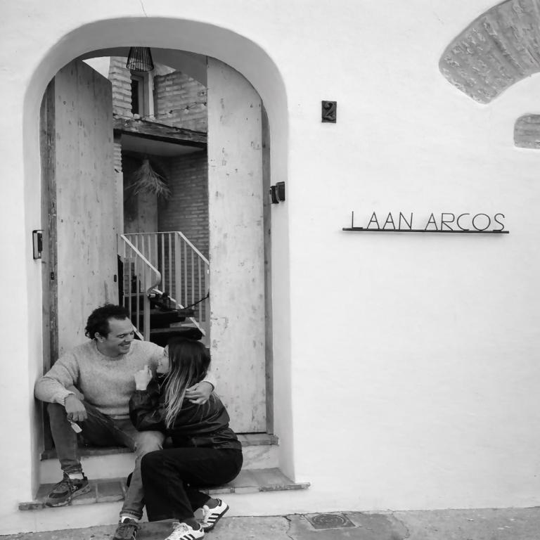 a man and a woman sitting on a window sill at Laan Arcos, casa cueva in Arcos de la Frontera