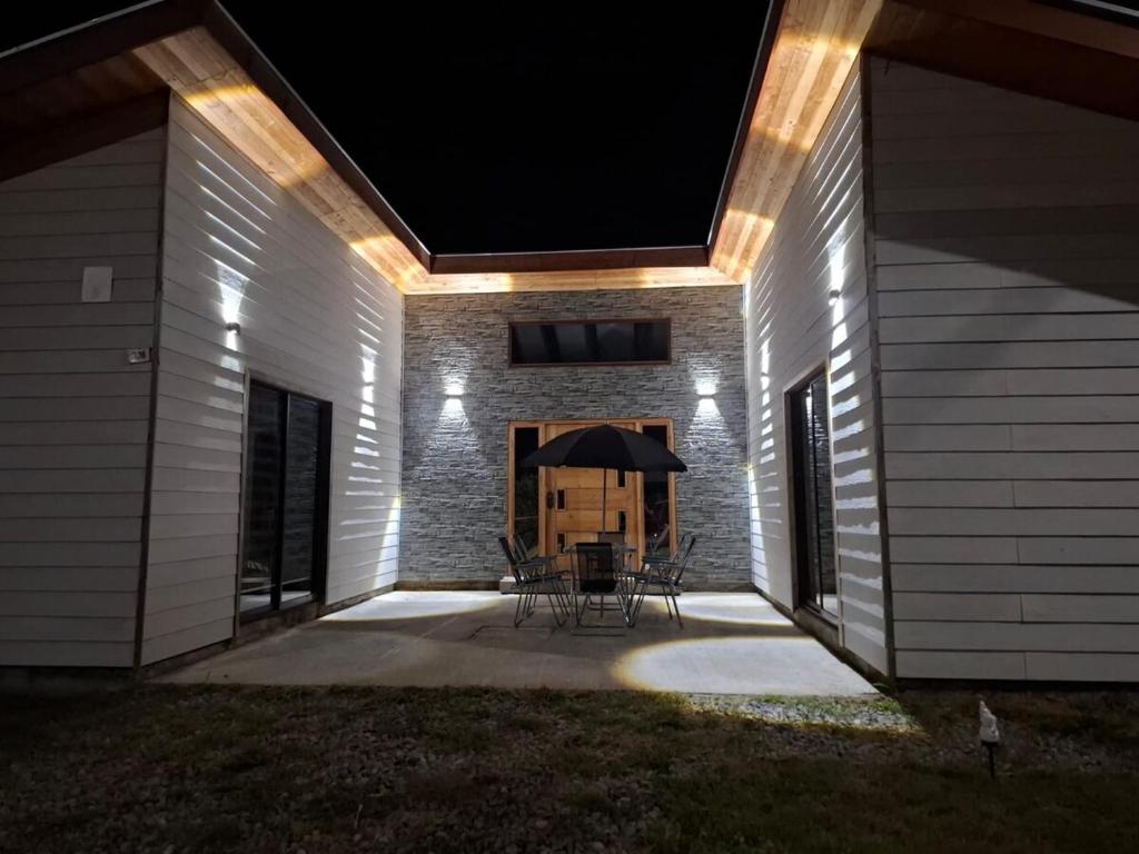 a patio at night with a table and an umbrella at Casa para 8 personas in Licán Ray