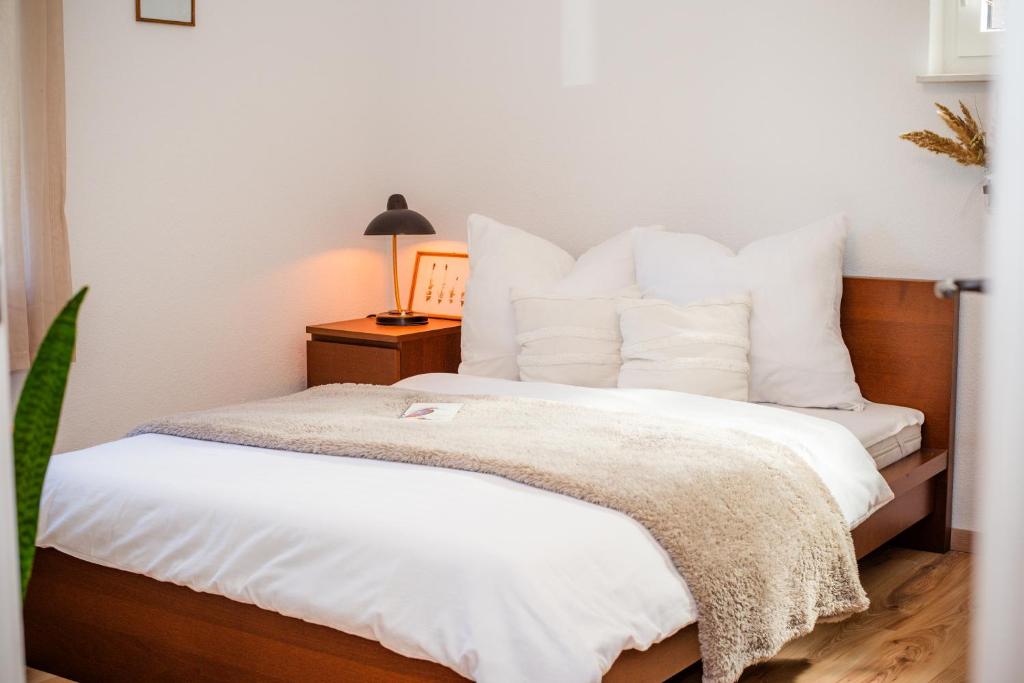 a bedroom with a bed with white sheets and a lamp at Ferienhaus Peenegrün in Jarmen