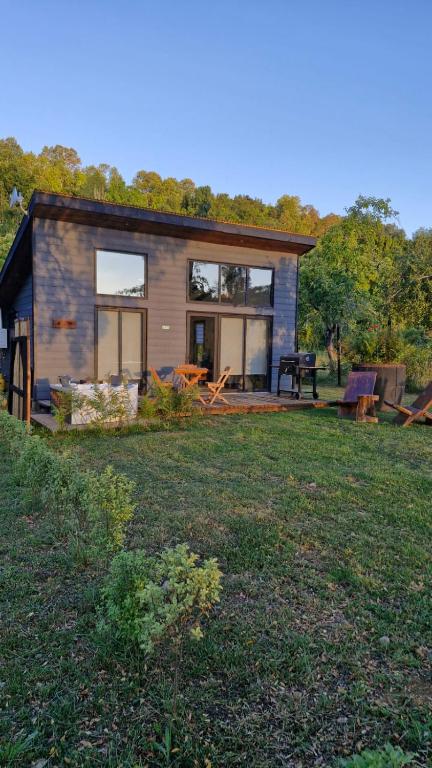 a small house in a field with a yard at Lodge para parejas con jacuzzi hidromasaje in Panguipulli