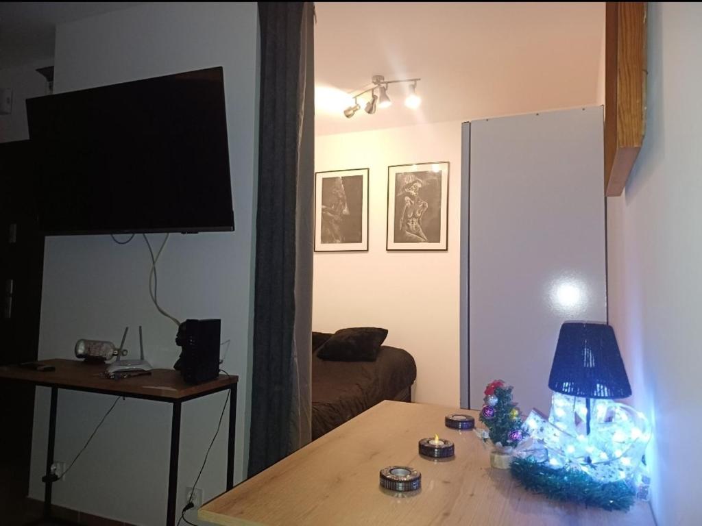 a living room with a table with a lamp on it at Crystal Baltic Studio Gdańsk self check in - 24h in Gdańsk