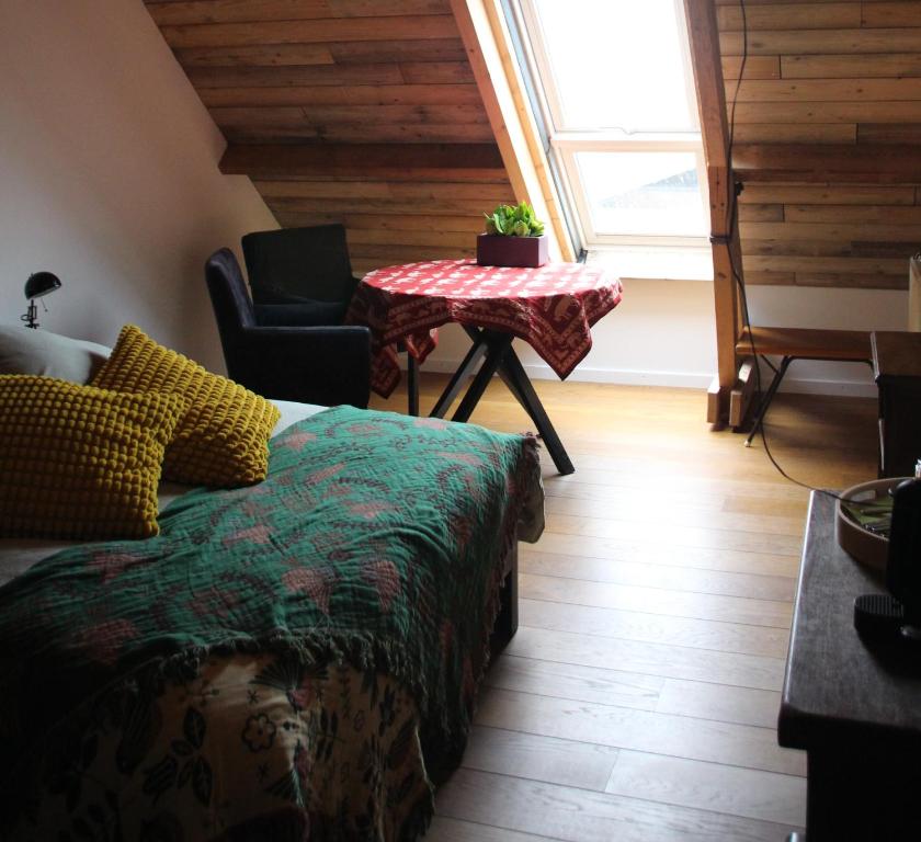 a bedroom with a bed and a table and a window at B&B Even Heukelom - Kamer 2 in Afferden