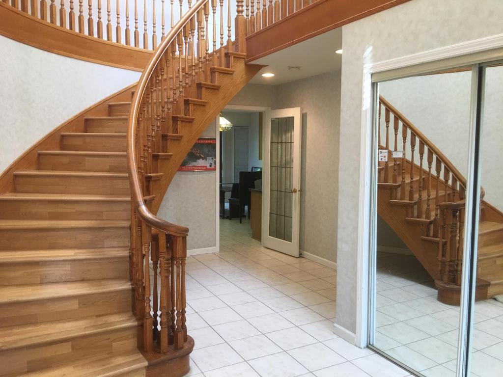 eine Holztreppe in einem Haus mit Flur in der Unterkunft Vancouver Homestay Inn in Richmond