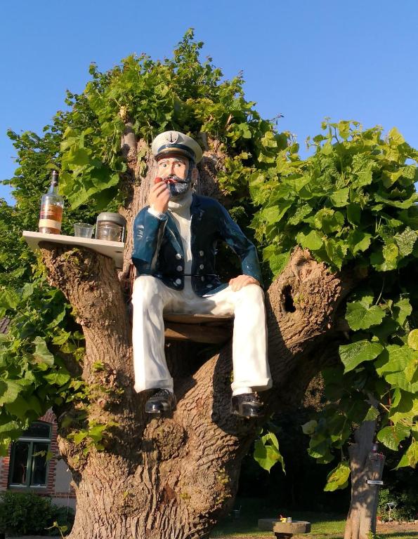 a statue of a man sitting in a tree at Gutshaus Breesen in Laage