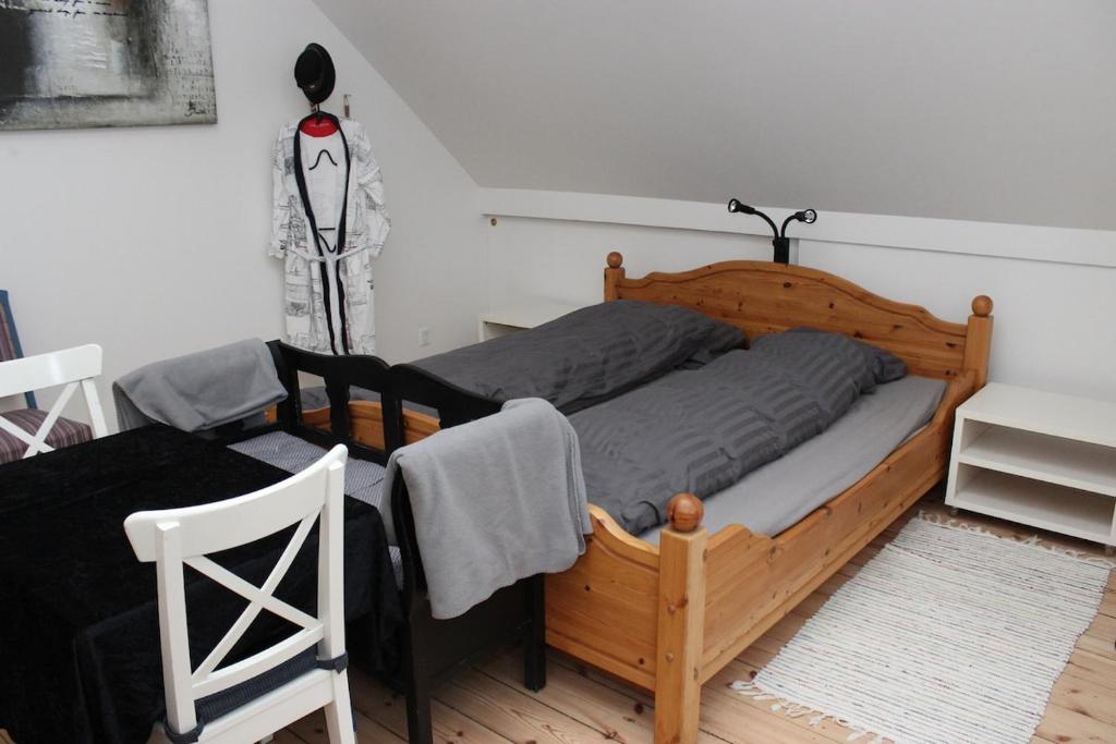 a bedroom with a wooden bed and a chair at 1st floor 2 rooms with kitchenette in Store Heddinge