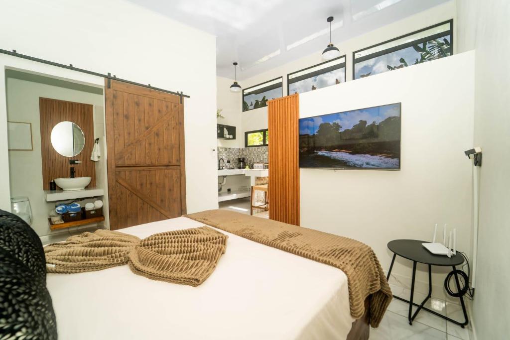 ein Schlafzimmer mit einem großen Bett und ein Badezimmer in der Unterkunft Inta Tiny House in Fortuna