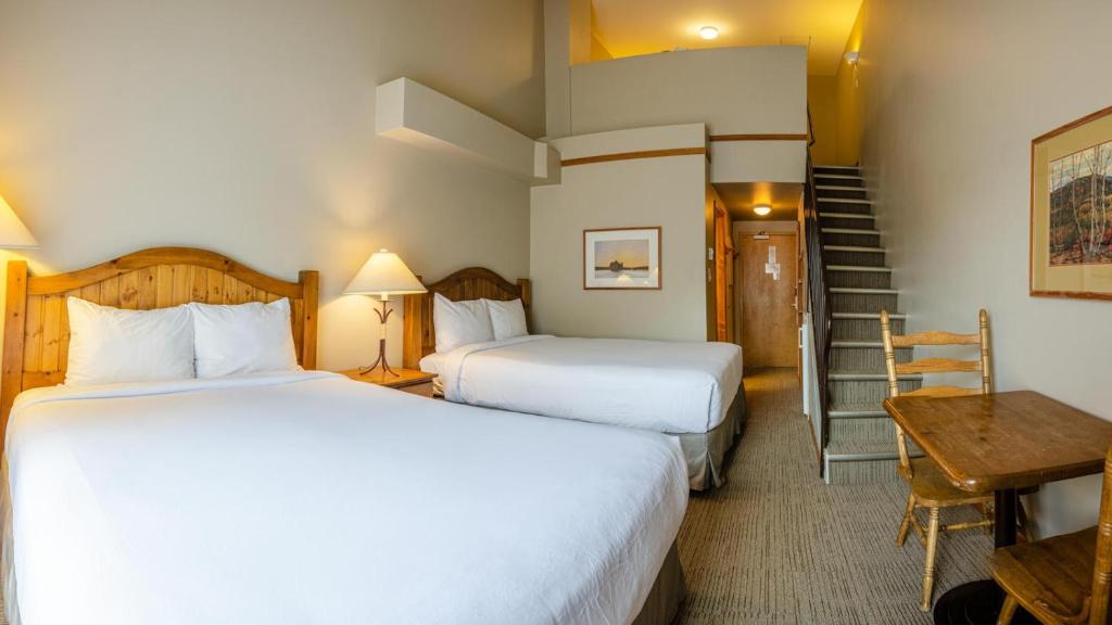 a hotel room with two beds and a staircase at Cahilty #434 home in Sun Peaks