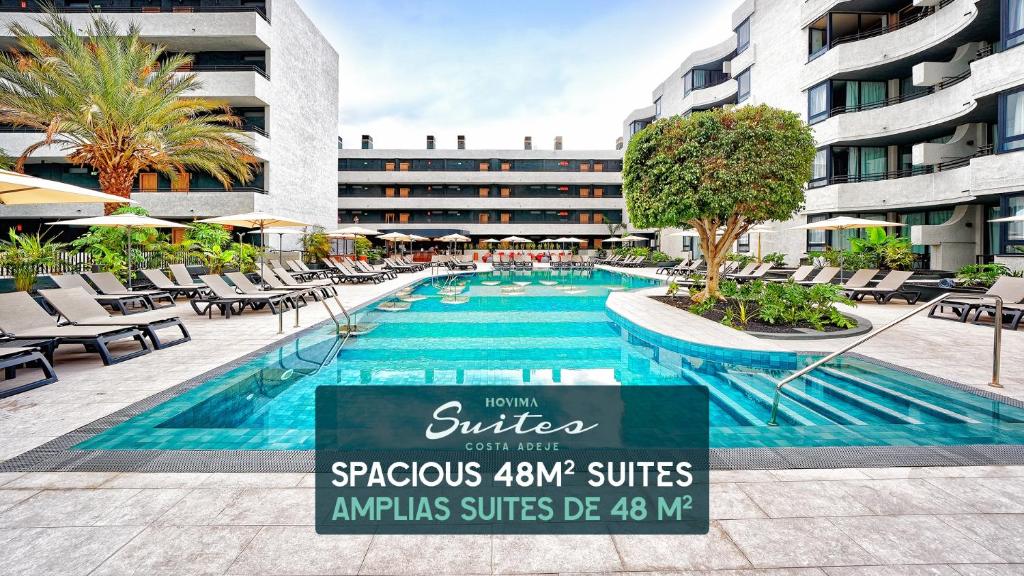 a swimming pool with lounge chairs and a hotel at HOVIMA Suites Costa Adeje in Adeje
