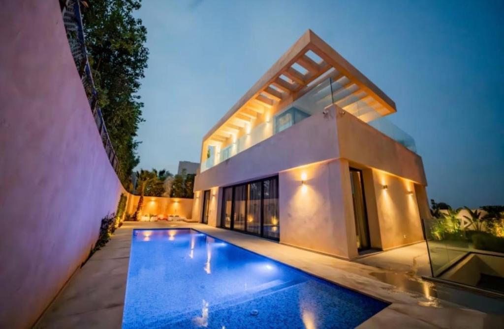 a house with a swimming pool at night at Villa Horizon in Marrakesh