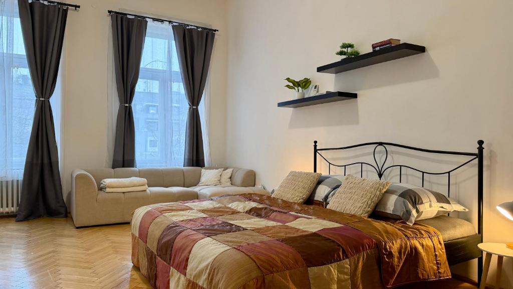 a bedroom with a bed and a couch at Apartment Hviezdko - Heart of Old Town in Bratislava