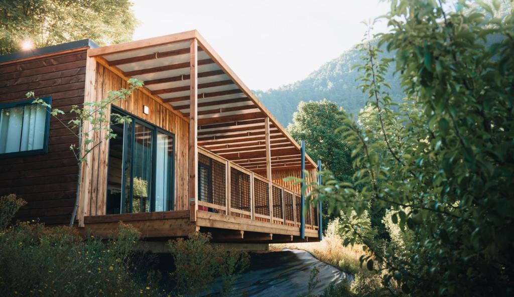 a wooden house with a balcony on a mountain at Valterra Lodges à Châtillon-en-Diois in Châtillon-en-Diois