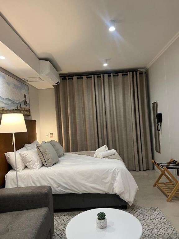 a bedroom with a large bed and a couch at Executive Studio at Ellipse Galileo - Waterfall in Midrand