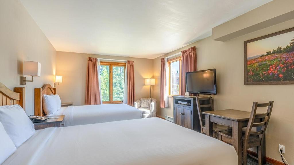 a hotel room with two beds and a television at Cahilty #265 in Sun Peaks