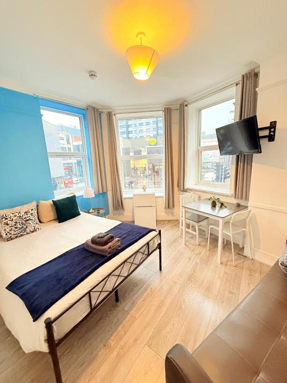 a bedroom with a bed and a tv and a table at Wandsworth Guest Rooms 64 in London