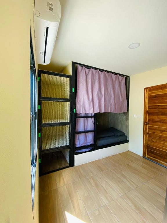 a room with a bed and a window at The 10 Club Hostel & Tiny Villas in Thong Sala
