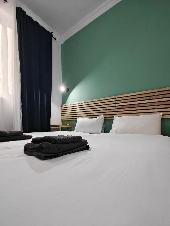 a large white bed in a bedroom with a blue wall at Cosy room 2 in Pieta