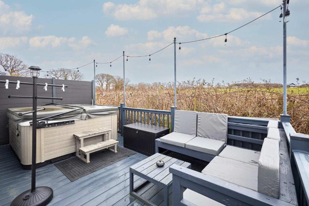 a deck with a hot tub and a bench and a grill at Host & Stay - Long View Lodge in Felton