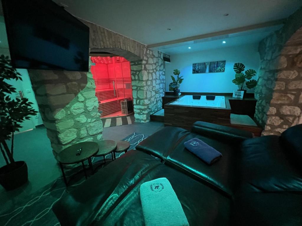 a living room with a couch and a stone wall at Appart Spa Privatif in Reims