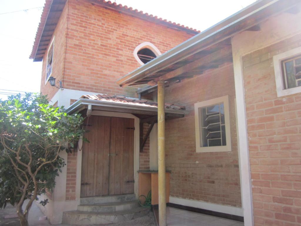 a brick house with a wooden door on it at Chácara Famille Brun in São João da Boa Vista