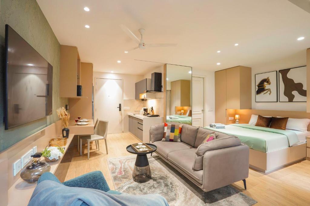 a living room with a couch and a bed at Aerovista Suites - Neon Homeotel- 1 kms from Airport in Pune