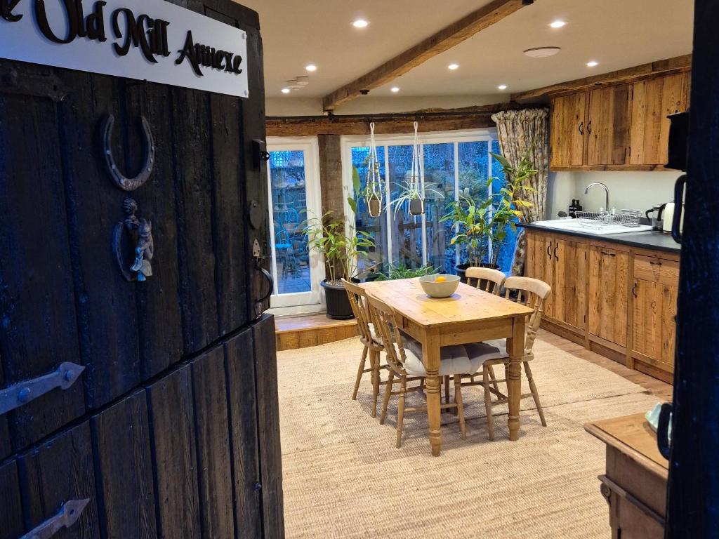 a kitchen and dining room with a wooden table and chairs at The Old Mill Annexe in Jacobstowe