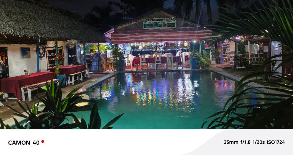 ヌシ・ベーにあるPiscine bimokoのテーブルと椅子が置かれた夜のプール