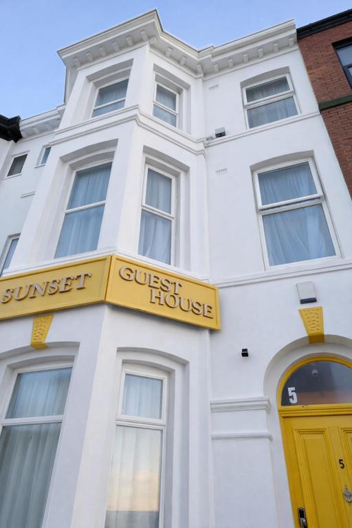a white building with a yellow guest house at Sunset Suites in Blackpool